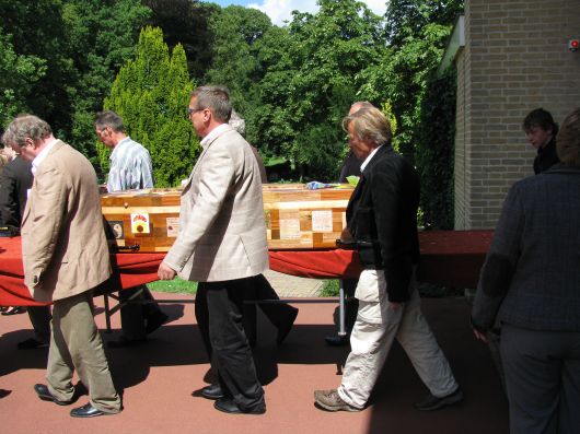 De kist wordt naar buiten gedragen