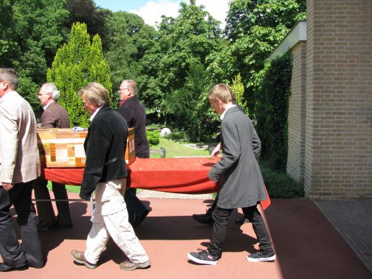 De kist wordt naar buiten gedragen